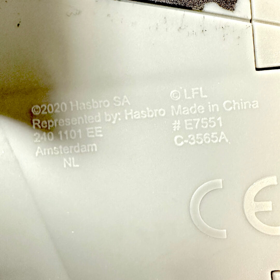 Close-up of the gray plastic underside of a toy, showing embossed text including 'Hasbro', 'Made in China'.