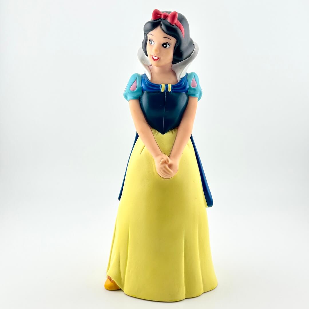Toy figure of a princess in a yellow and blue dress on a white background