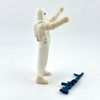 Toy figure of a character in a white suit with a blue weapon on a light gray background