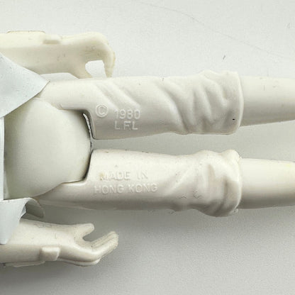Close-up of a white plastic action figure's lower legs and hands, showing embossed text '© 1980 L.F.L'