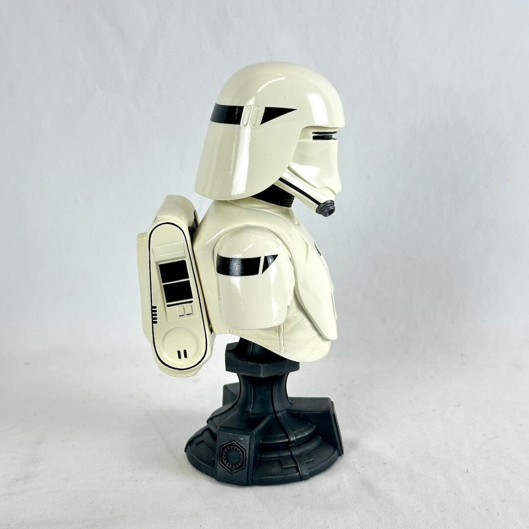 A glossy white and black toy bust of a sci-fi helmeted character on a black display stand.