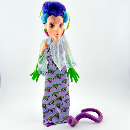 Toy figure with purple hair and dress on a white background