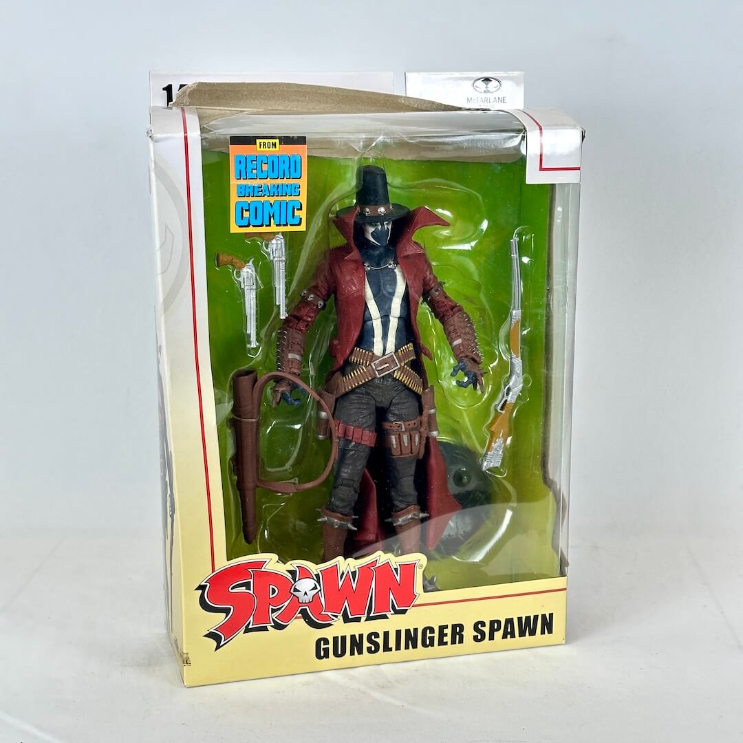 Spawn Gunslinger action figure in its original packaging, with accessories visible inside the clear plastic window.