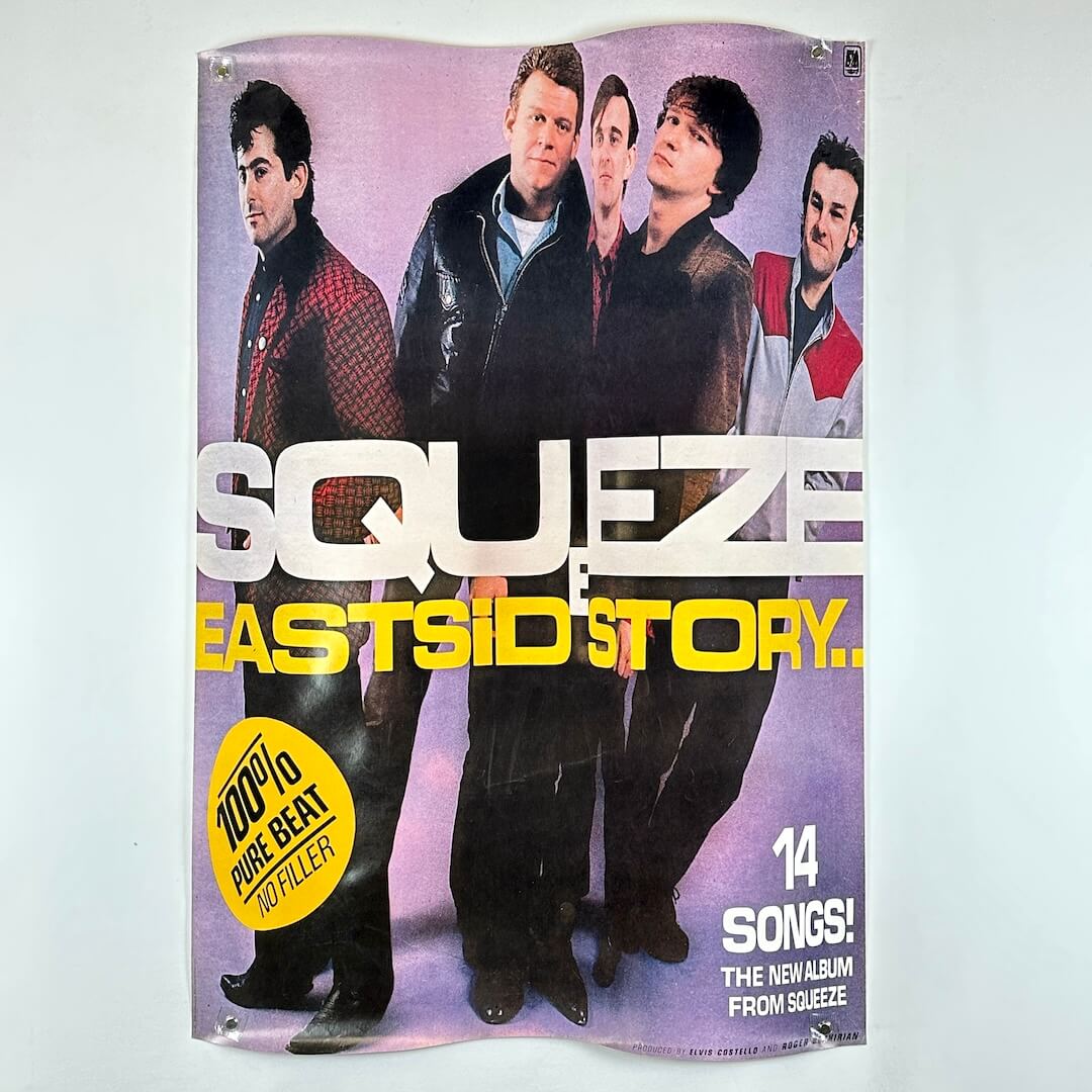 Promotional poster for Squeeze's 'East side Story' album with band members on a purple background.