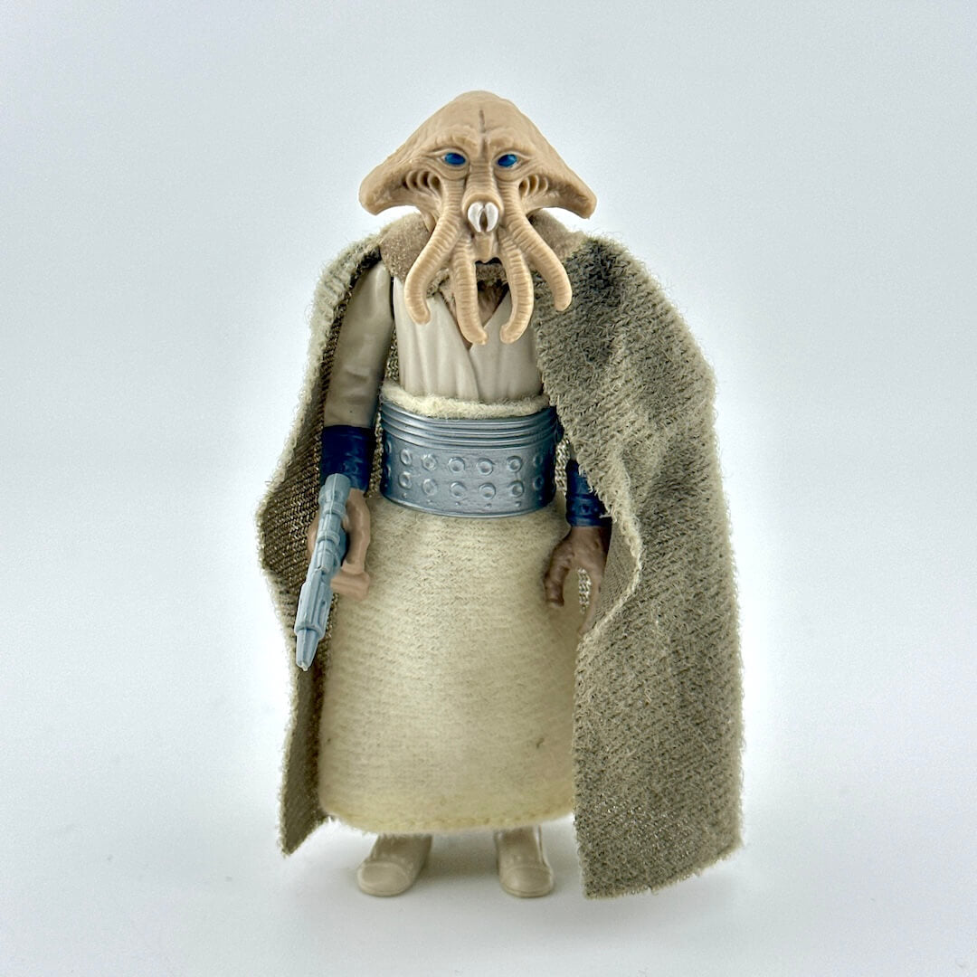 Sci-fi franchise action figure with cloak and weapon on white background. 