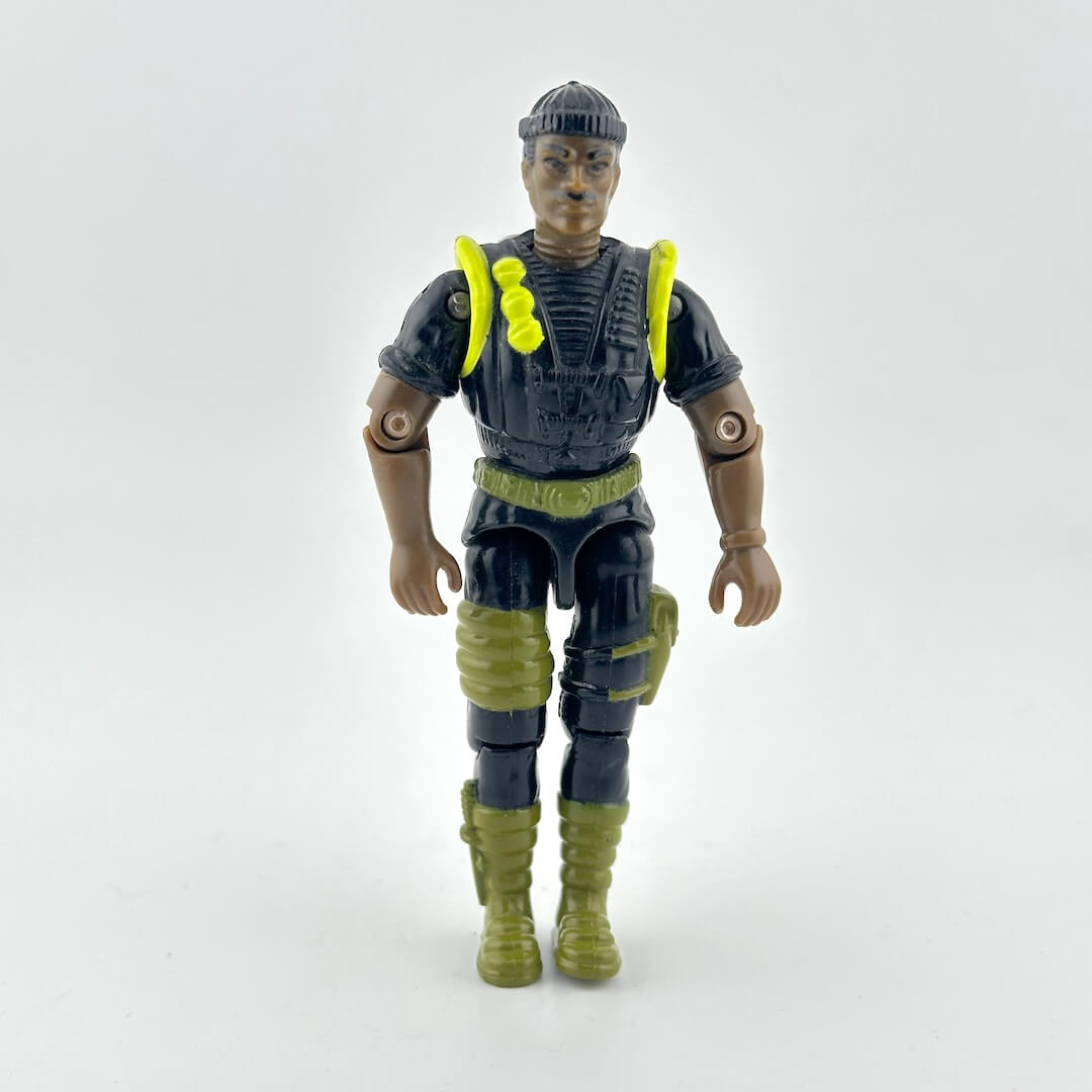 GI Joe action figure in black military outfit with green and yellow accents, photographed against white background. 