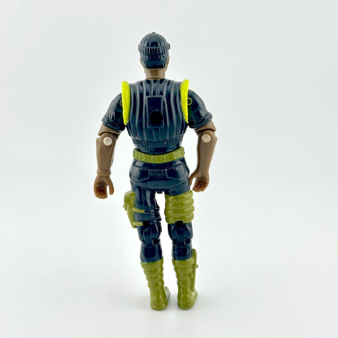 GI Joe action figure in black military outfit with green and yellow accents, photographed against white background. 