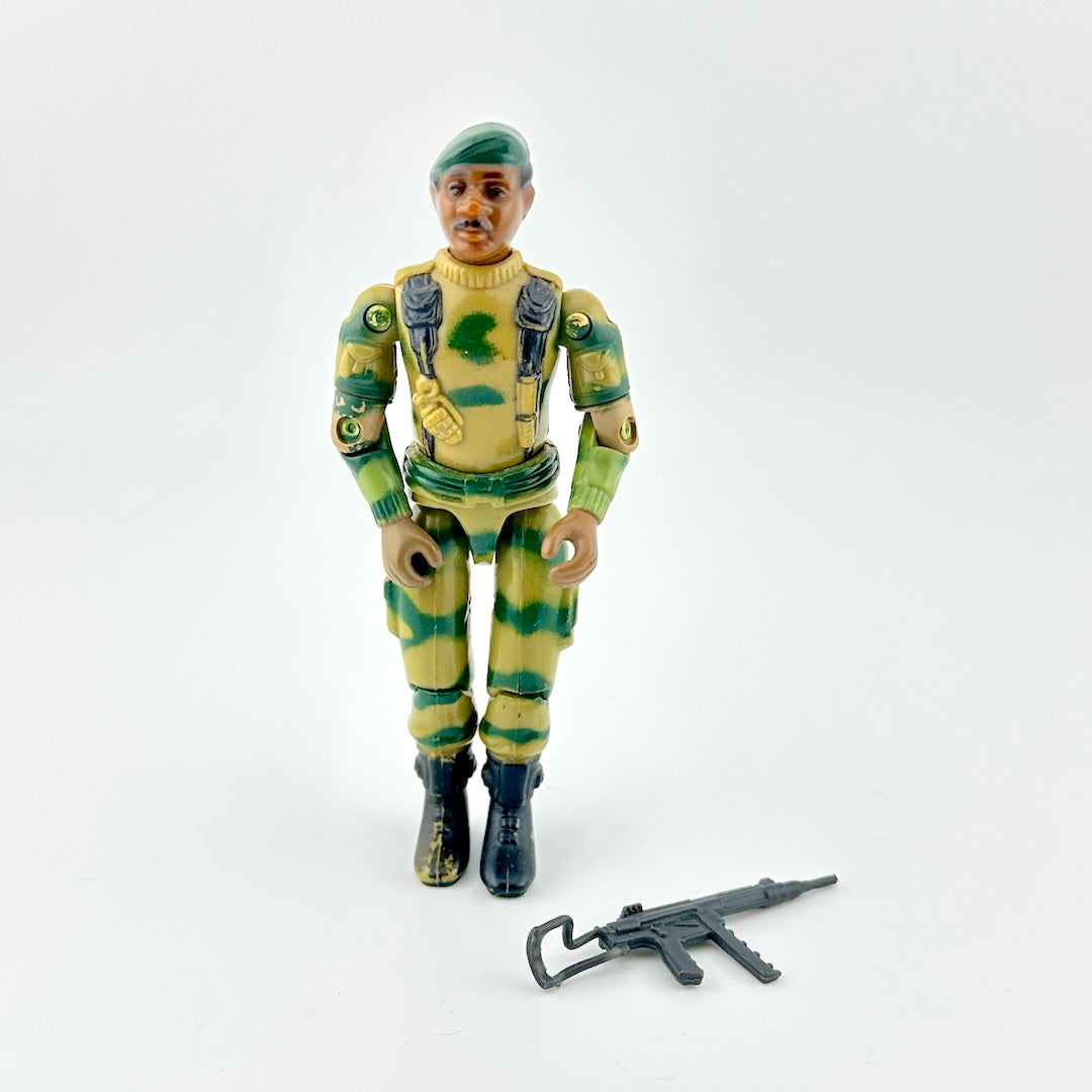 Toy figure in camouflage uniform with weapon on a white background