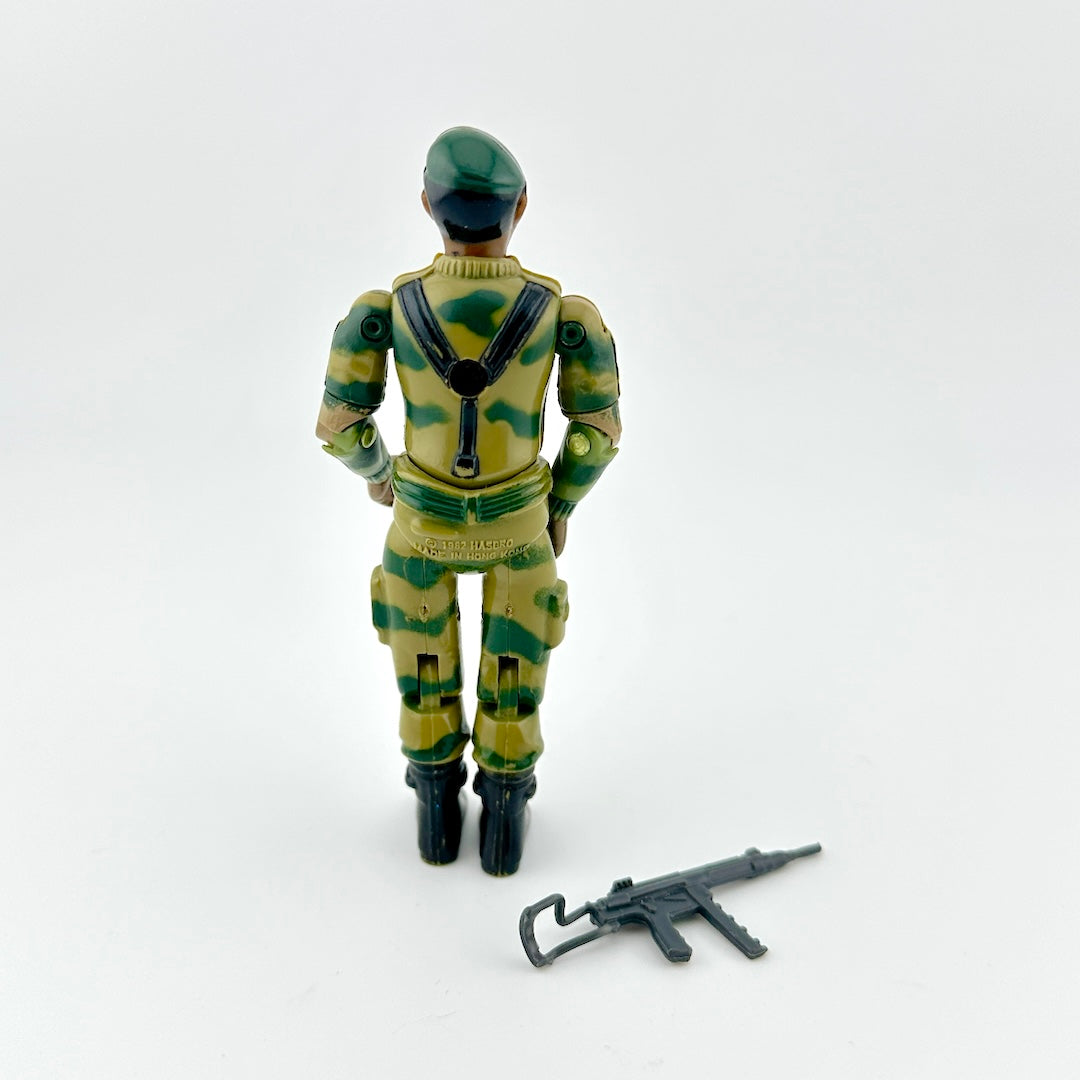 Toy figure in camouflage uniform with a weapon on a white background