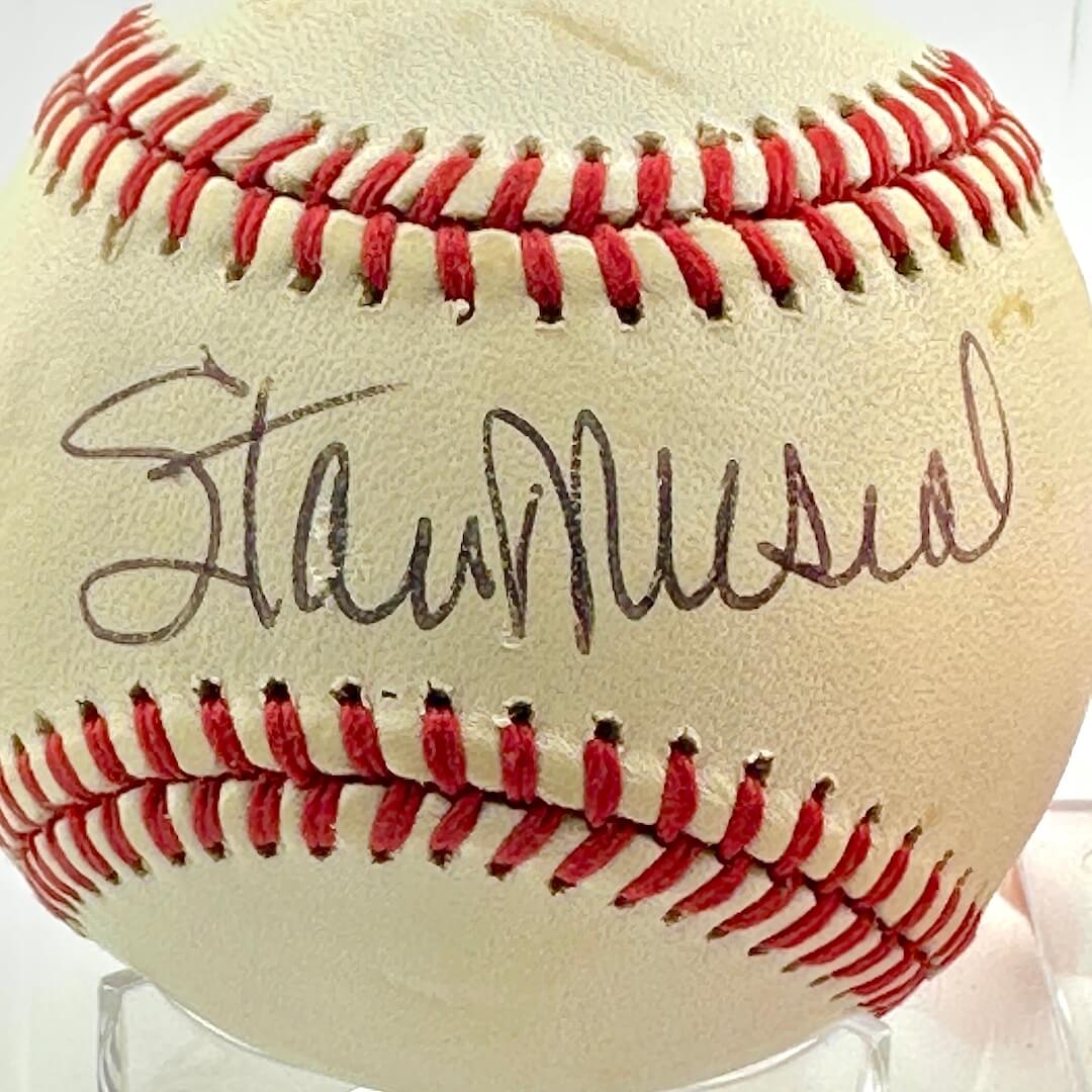 Baseball with red stitching and a signature on a white background