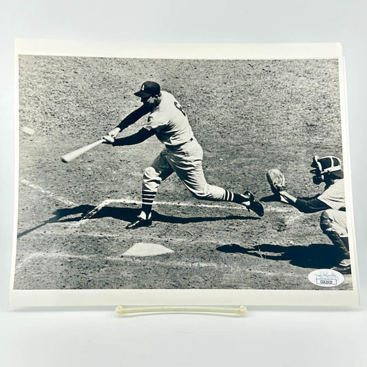 Black and white photo of baseball player swinging bat at incoming ball, signed in silver ink along bottom. 