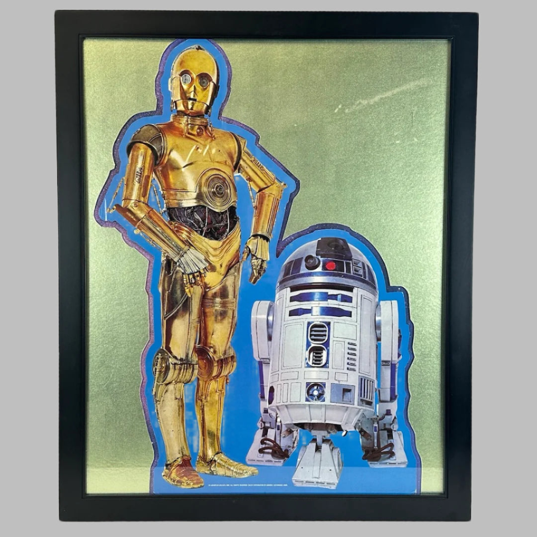 Black frame, gold mat around cardboard standee of C3PO & R2D2 droids on blue background.