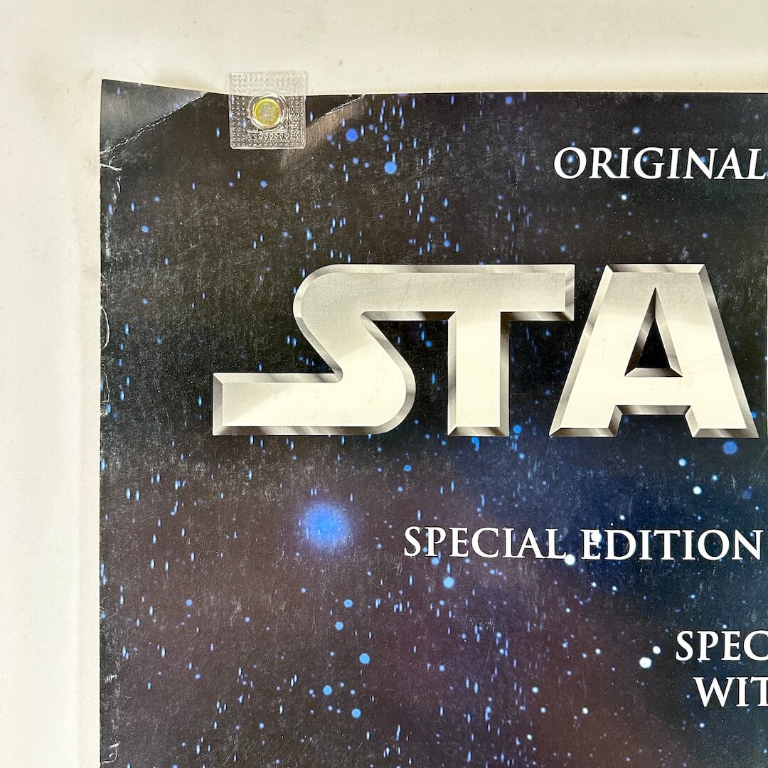 Top left corner of poster with crease at corner and some edge wear. 