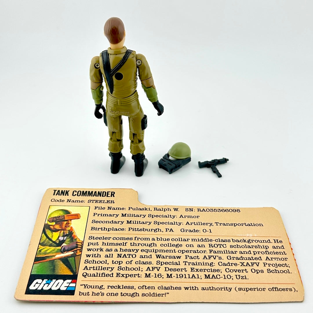 GI Joe action figure with accessories and character card on white background. 
