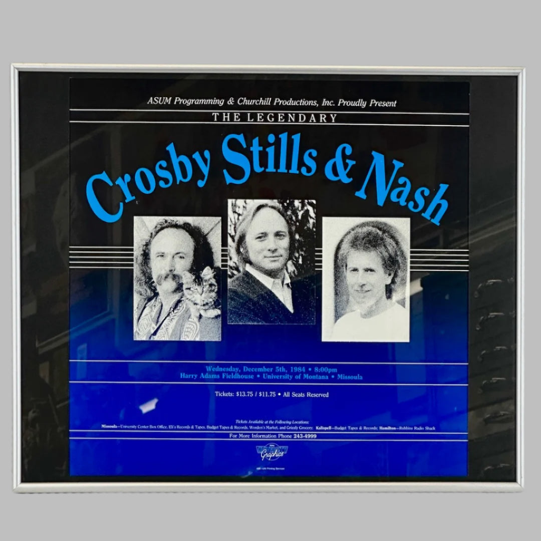 Black poster ombre into blue with 3 photos of men under blue "Crosby Stills & Nash" event info in blue & white text below.