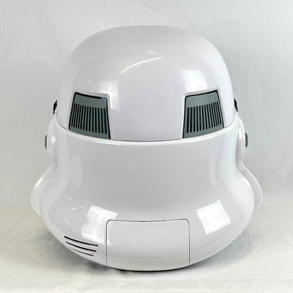 A glossy white helmet resembling a sci-fi stormtrooper, photographed from the back against a light gray fabric backdrop.