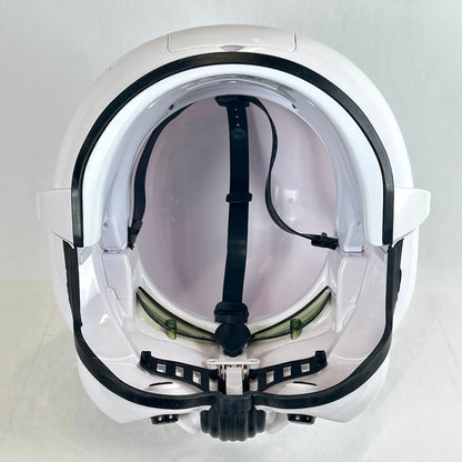 The inside view of a white full-face helmet with black trim, black chin strap, and clear visor, photographed against a plain light background.