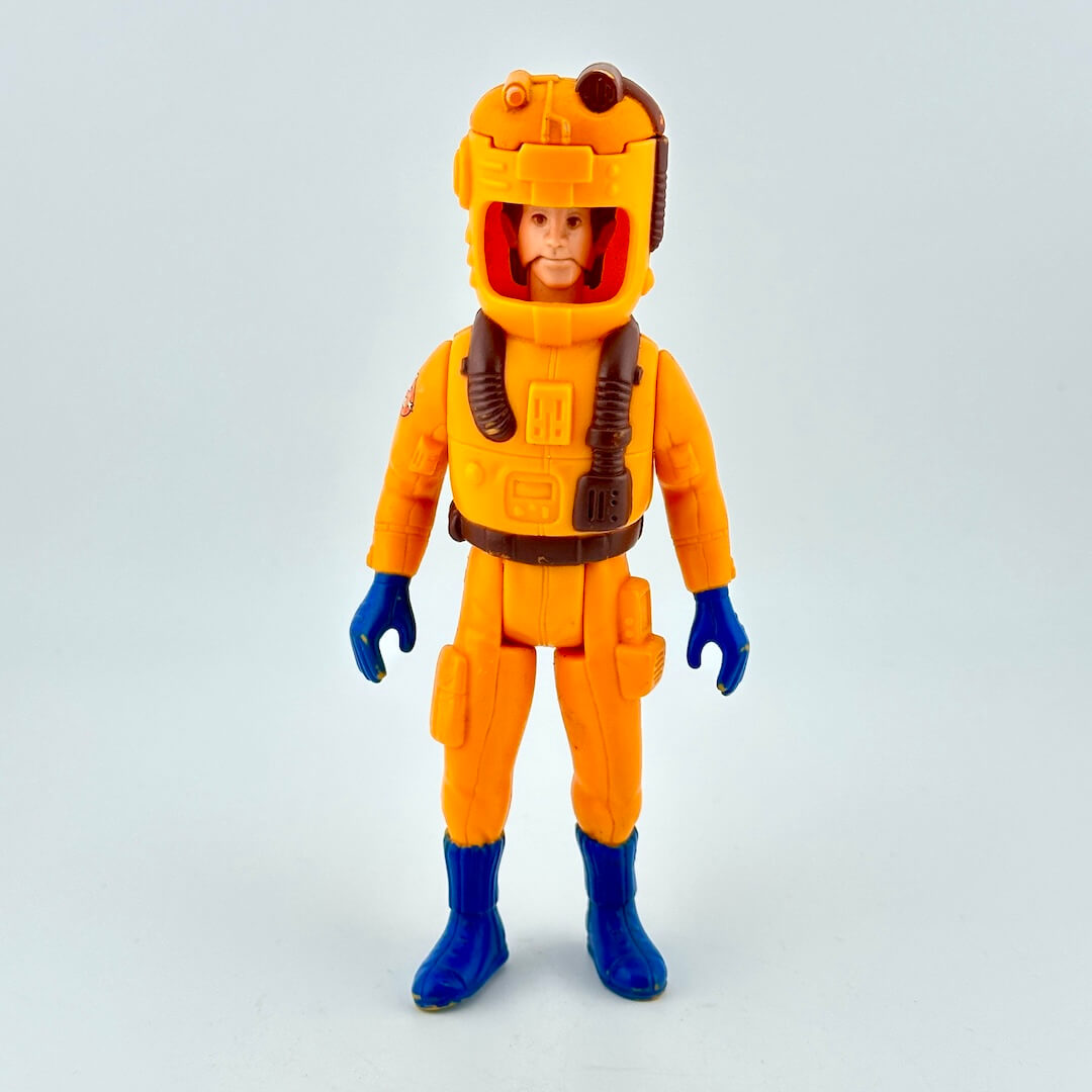 Toy figure in an orange space suit with a helmet on a light gray background