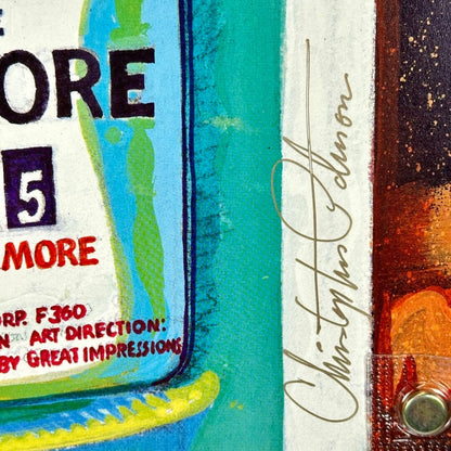 Close up of artist signature in gold along bottom right corner. 