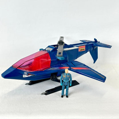 A blue and red toy jet airplane model displayed with a small blue-and-gray action figure.