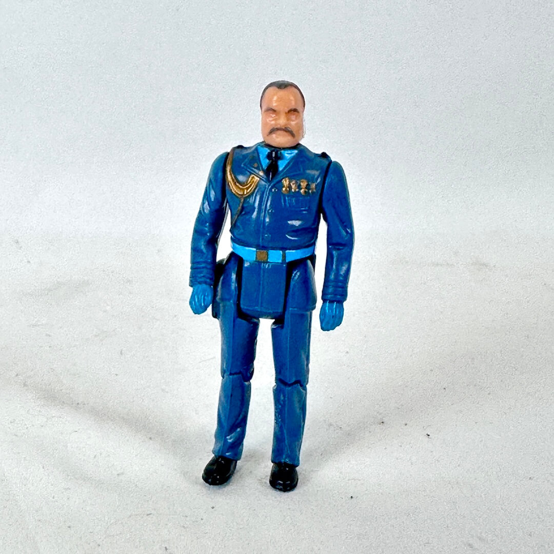 A vintage plastic action figure of a man in a blue military-style uniform with gold accents.