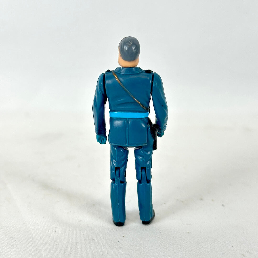 A vintage action figure of a man in a blue uniform, shown from the back.