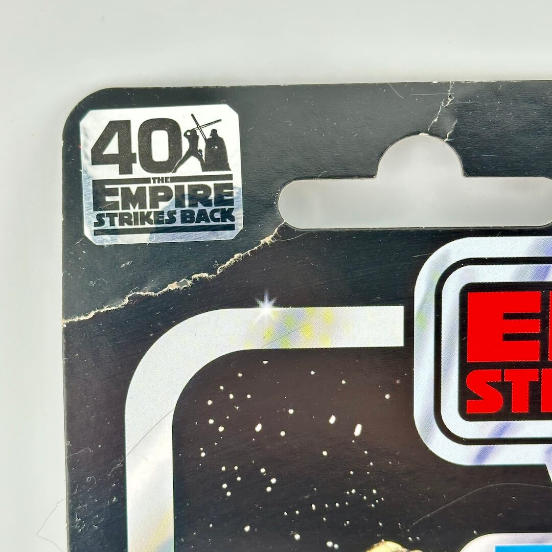 Close-up of Star Wars action figure packaging corner with crease below 40th Anniversary sticker. 