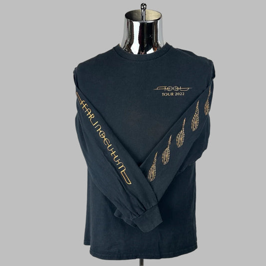 Black long sleeve shirt with band name on breast, tour name along one sleeve, and paisley design down other sleeve. 
