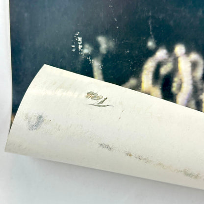 Bottom left corner rolled up to show "TOOL" written in black ink on reverse side. 