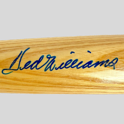 Wooden bat with blue signature on a beige background