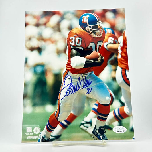 Autographed photo of a football player in action with visible signature and branding.