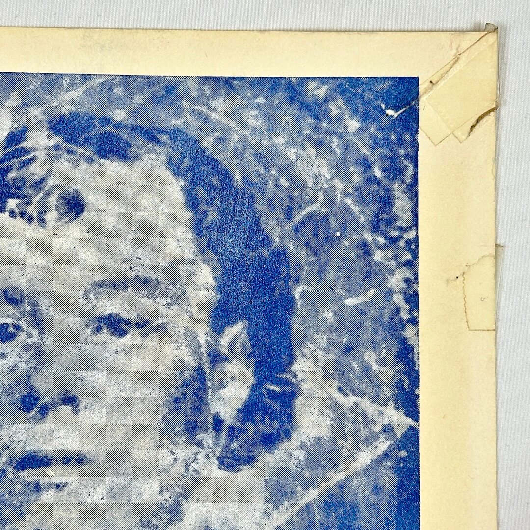 Top right corner of poster with tape marks and pin holes. 