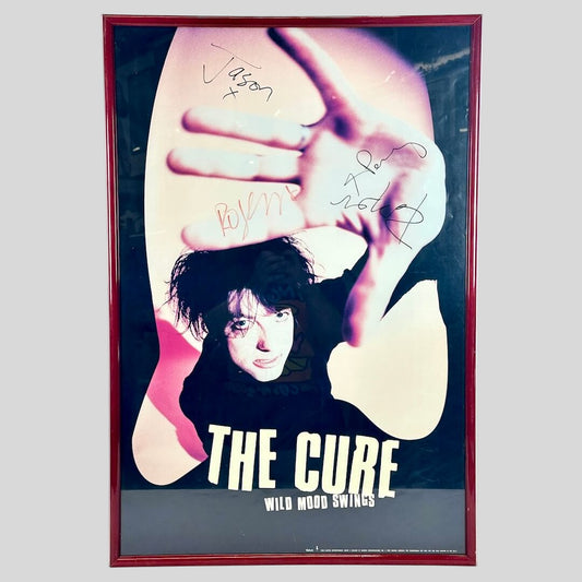 Poster of a person with 'The Cure' text, framed on a white wall.
