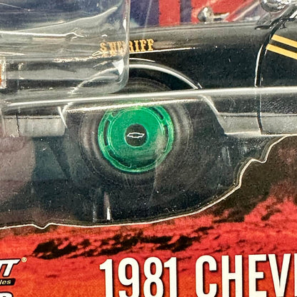 Close-up of a packaged diecast car, and a bright green wheel in center, inside clear plastic blister packaging.