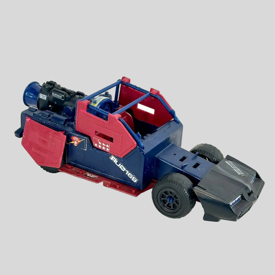 A vintage toy vehicle, featuring a blue body with red panels, black wheels, and a black front bumper.