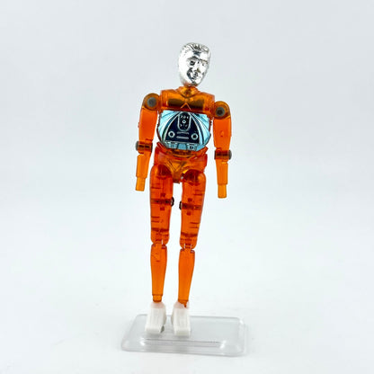 An articulated orange translucent plastic toy figure with a metallic silver head and white hands.