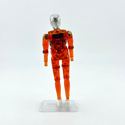 An articulated orange translucent plastic toy figure with a metallic silver head and white hands.