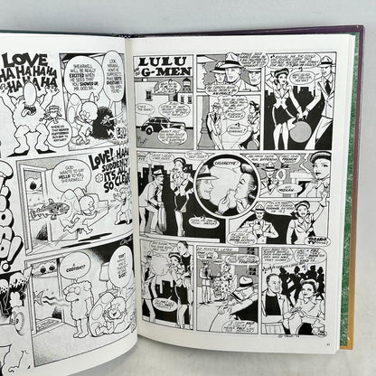 Open comic book with black and white illustrations on a gray background