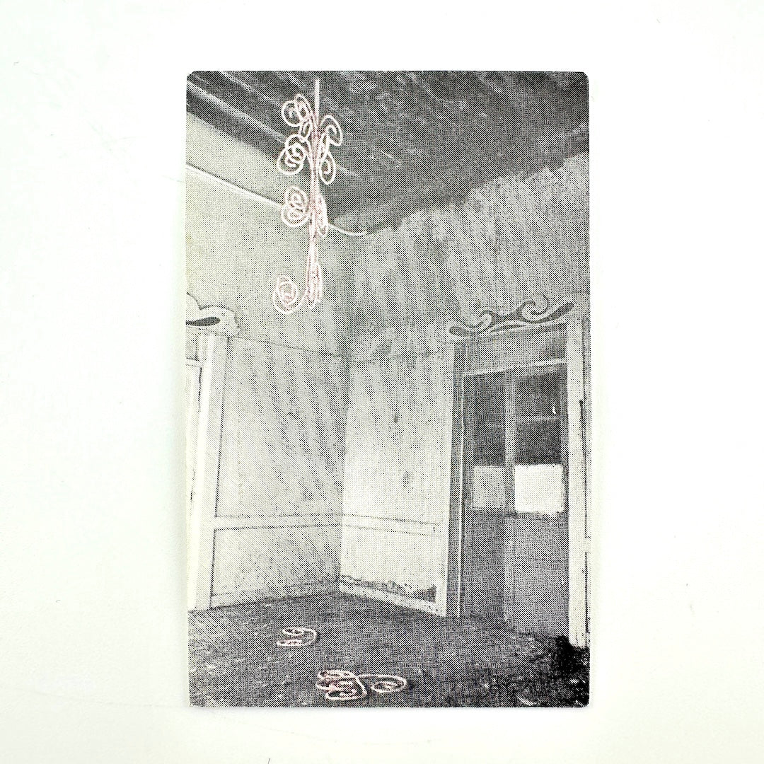 Backside of vintage laminate with black and white image of derelict room. 