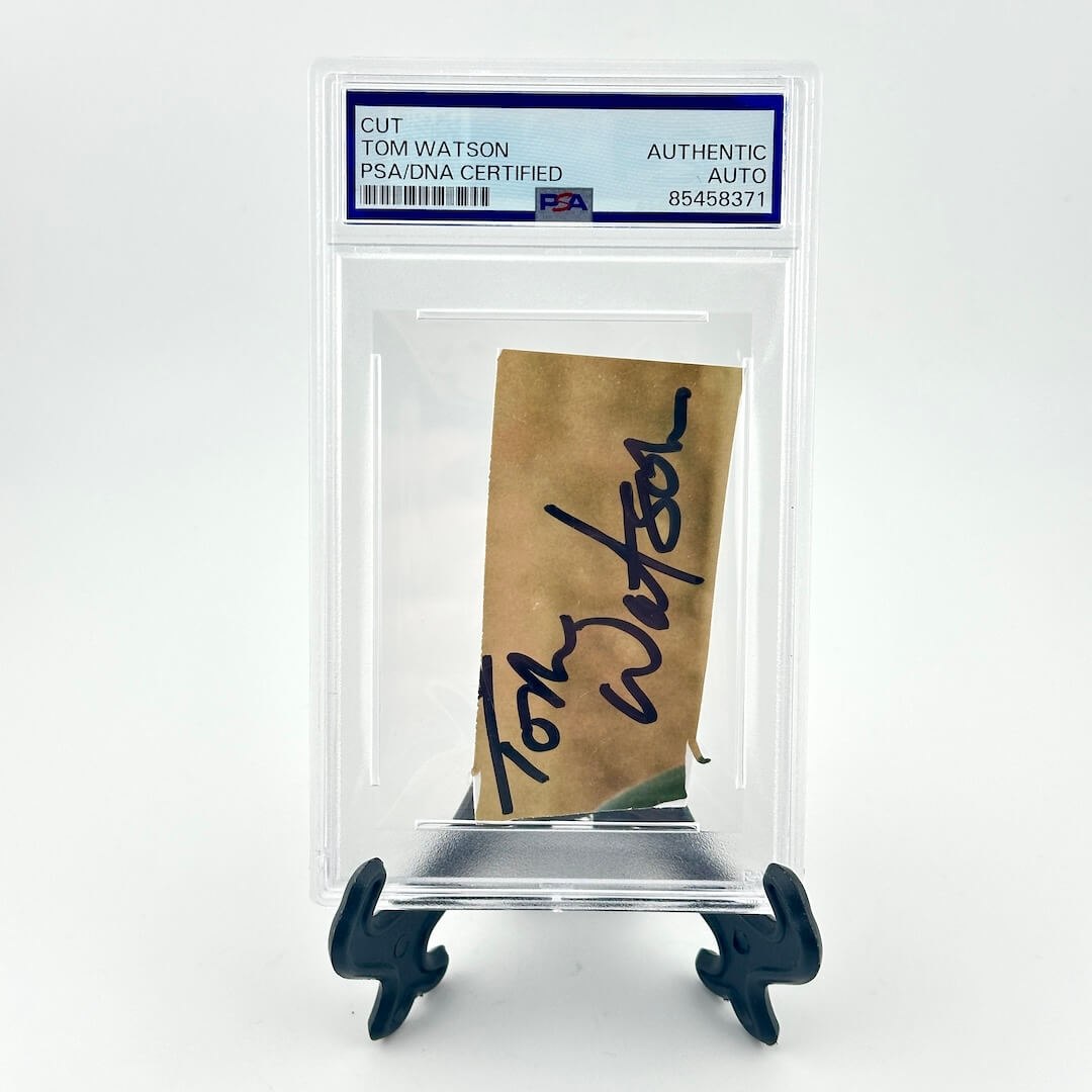Autographed piece of paper with a clear display case and certification label on a white background