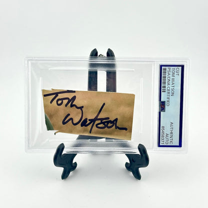 Autographed item on a stand with a clear protective case, featuring a signature and a label.