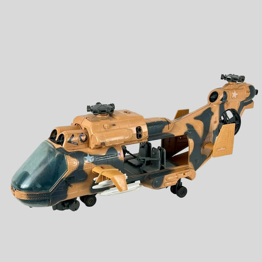 A toy military helicopter model in a desert camouflage pattern of tan and dark gray, displayed on a light gray background.
