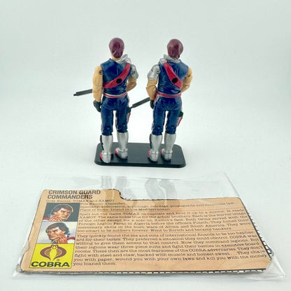 Two toy figures of Crimson Guard Commanders with a card in front on a white background