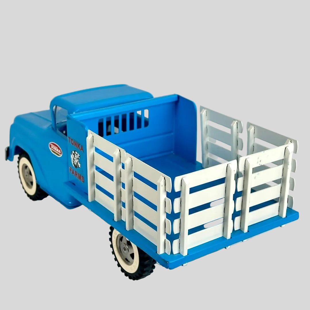 Blue toy truck with a white bed on a light gray background