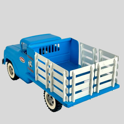Blue toy truck with a white bed on a light gray background