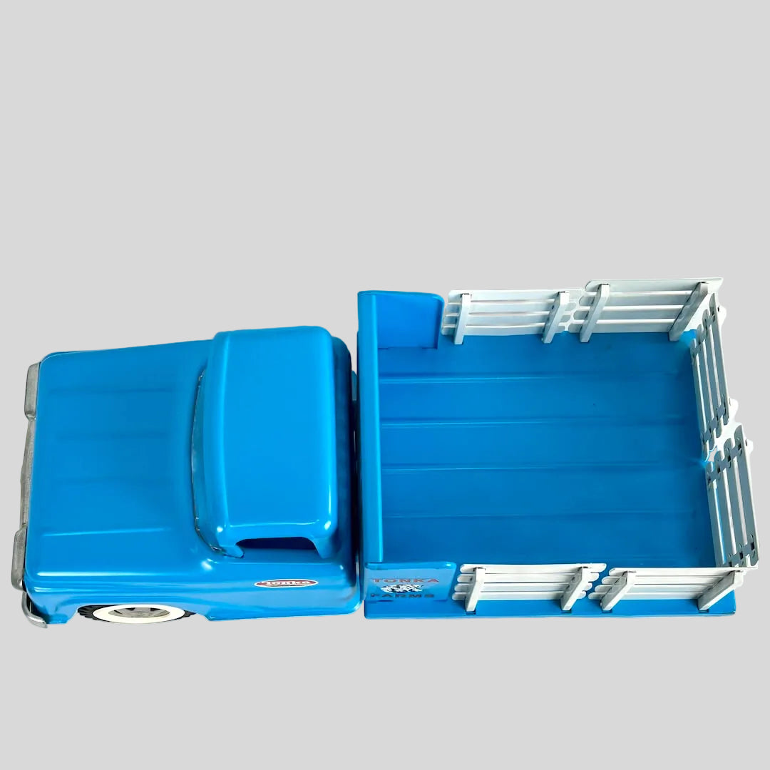 Top view of blue toy truck against gray background. 