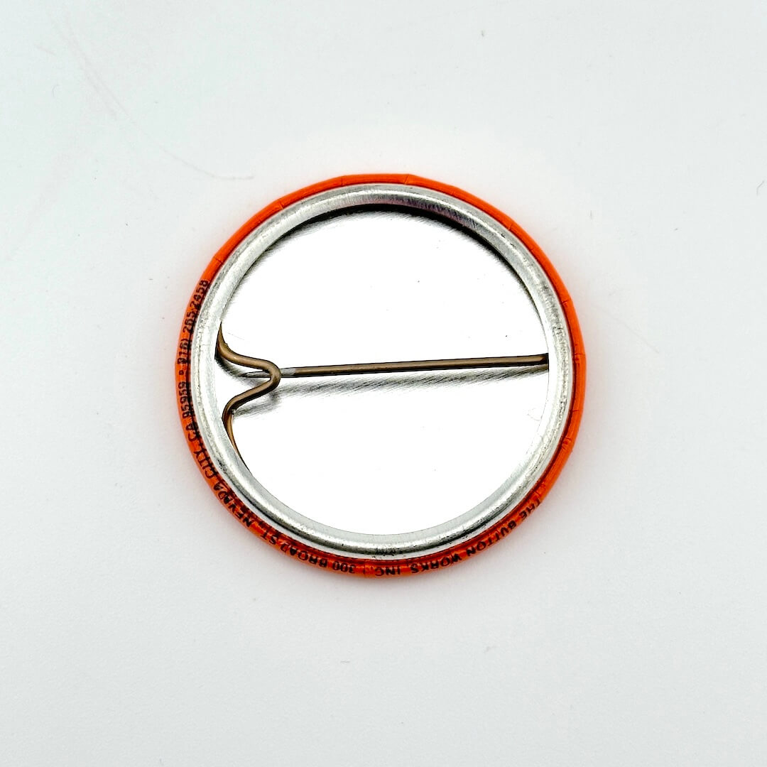 Metallic pin with orange rim on a white background