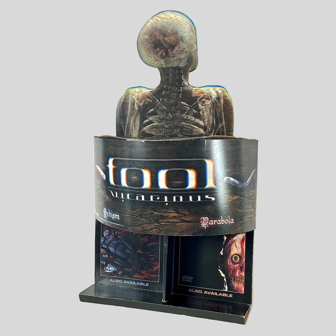 Side view of retail stand up display for TOOL with banner of single name under human skeleton design. 