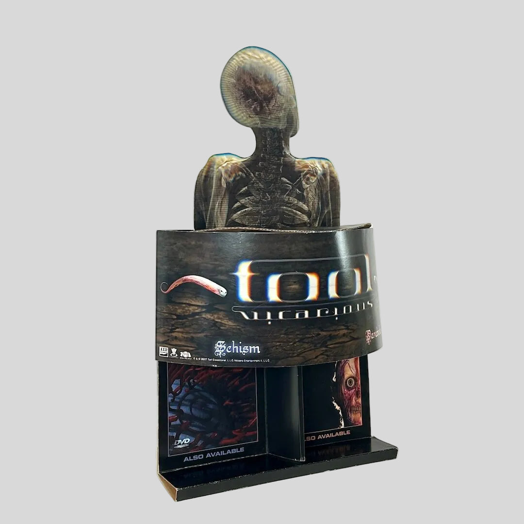Side view of retail stand up display for TOOL with banner of single name under human skeleton design. 