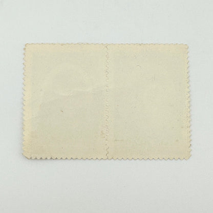 A blank, vintage-style cream-colored paper card with scalloped edges and a vertical center seam, displayed flat.